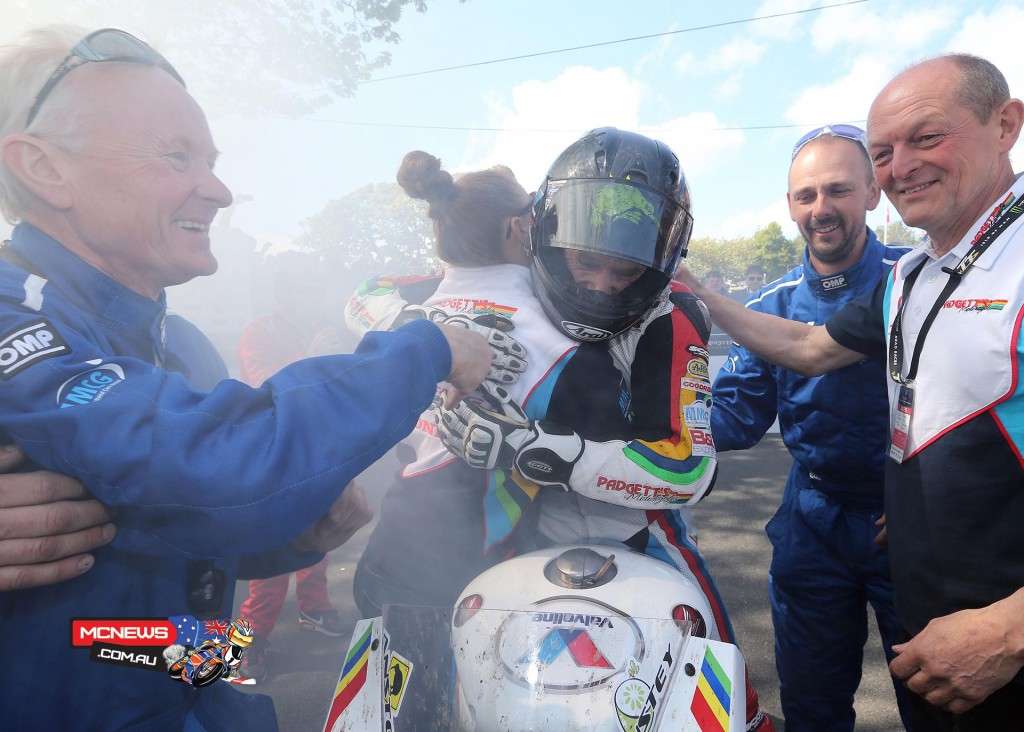 Bruce Anstey congratulated by his partner, team manager Clive Padgett and team members